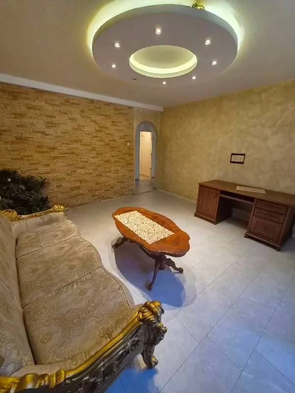 Living room with a sofa, coffee table and desk.
