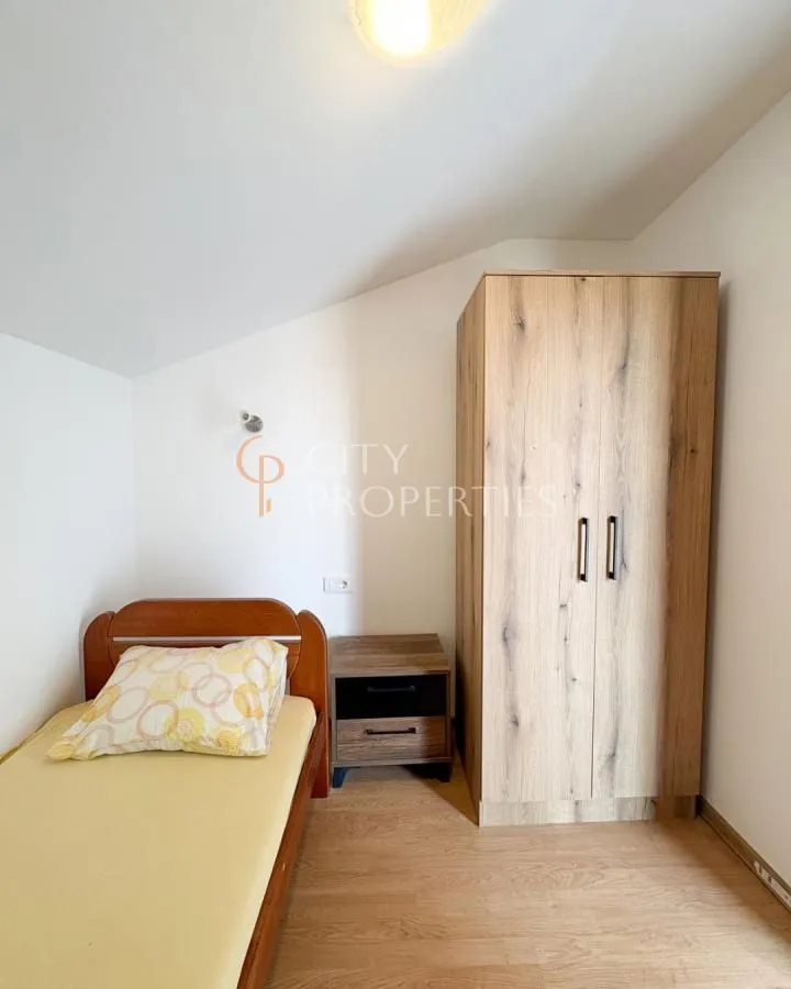 Small bedroom with a bed, nightstand, and wardrobe.