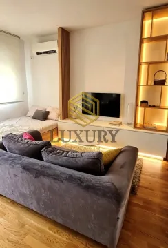 Living room with a sofa, TV, and built-in shelving unit. - image 3