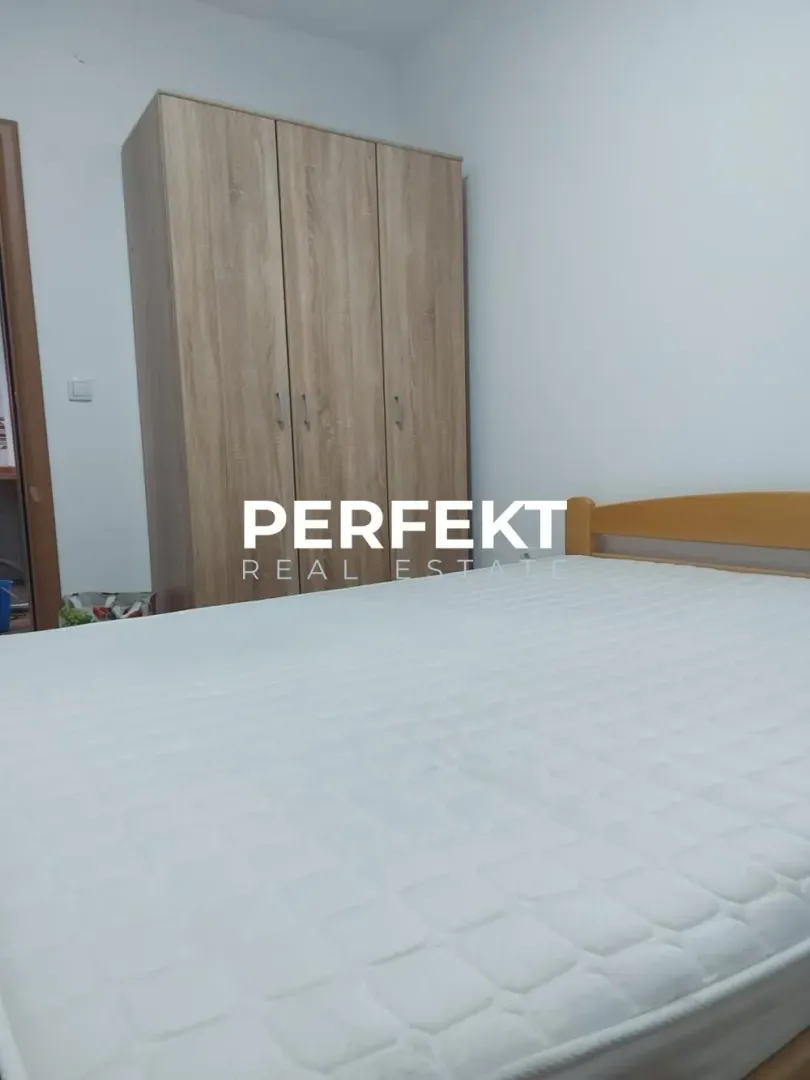 Bedroom with a double bed and wooden wardrobe.