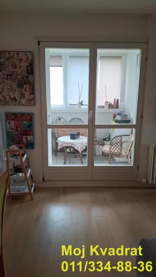 Pogled na zastakljenu terasu kroz balkonska vrata iz sobe.