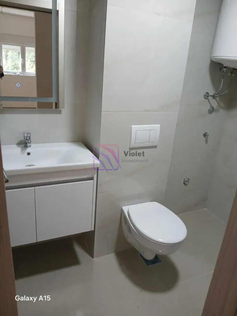 Savremeno opremljeno kupatilo sa umivaonikom, WC šoljom i tuš kabinom.