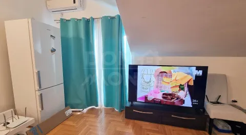 Dnevni boravak sa TV-om, frižiderom i prozorom sa plavim zavjesama. - image 7