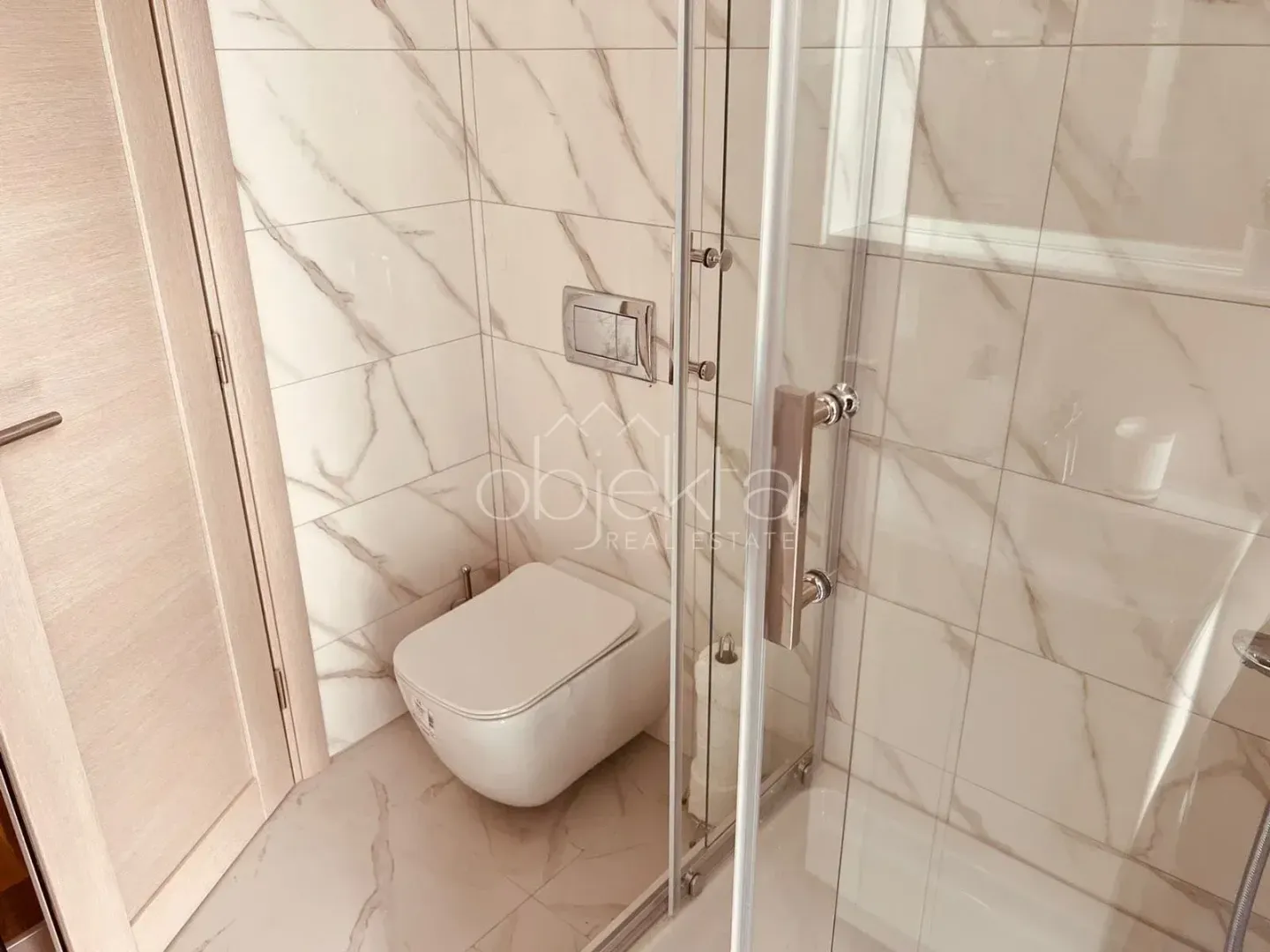 Modern bathroom with a shower cabin and a wall-hung toilet.