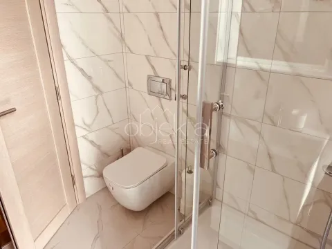 Modern bathroom with a shower cabin and a wall-hung toilet. - image 6