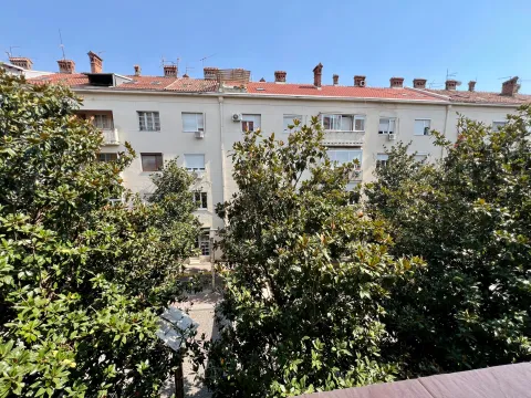 View from the apartment overlooking surrounding buildings and trees. - image 11