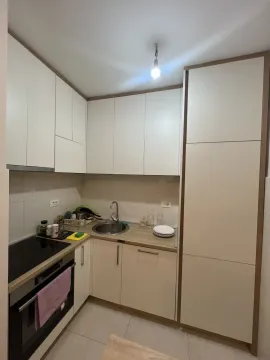 Small functional kitchen with white cabinets and built-in appliances. - image 6