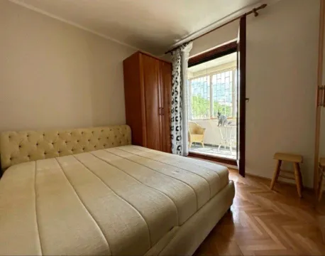 Spavaća soba sa bračnim krevetom, drvenim ormarom i izlazom na terasu. - image 4