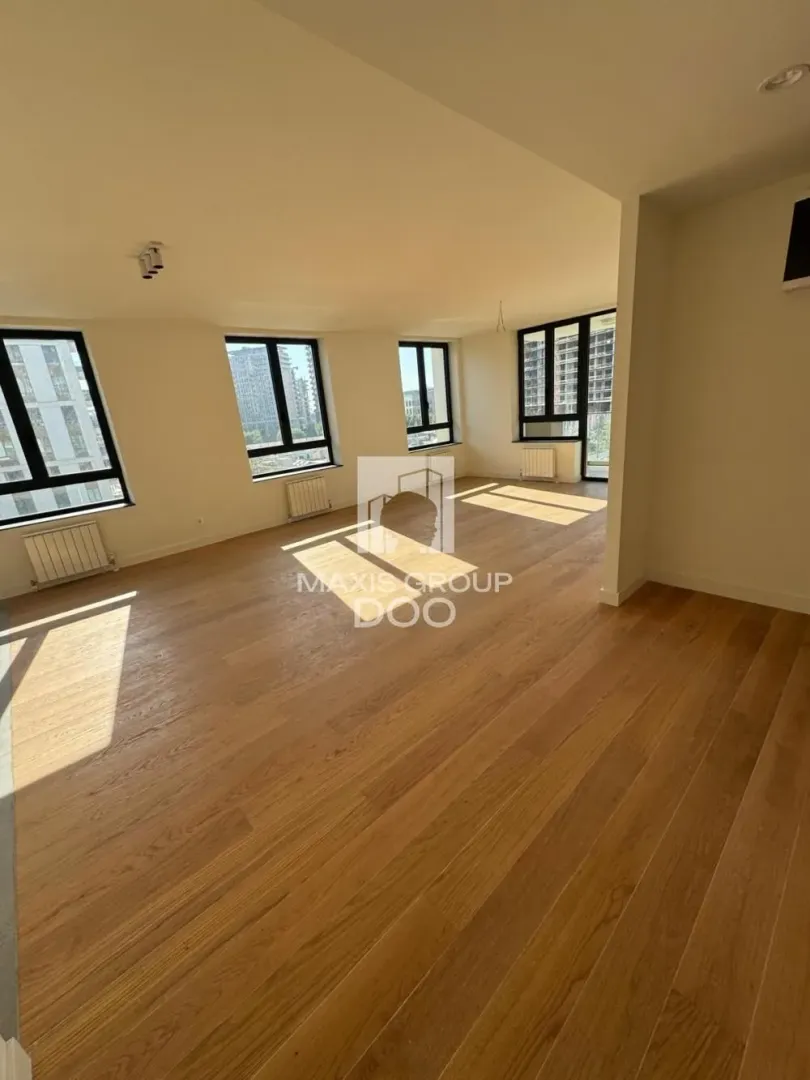 Spacious unfurnished living room with hardwood flooring and large windows.