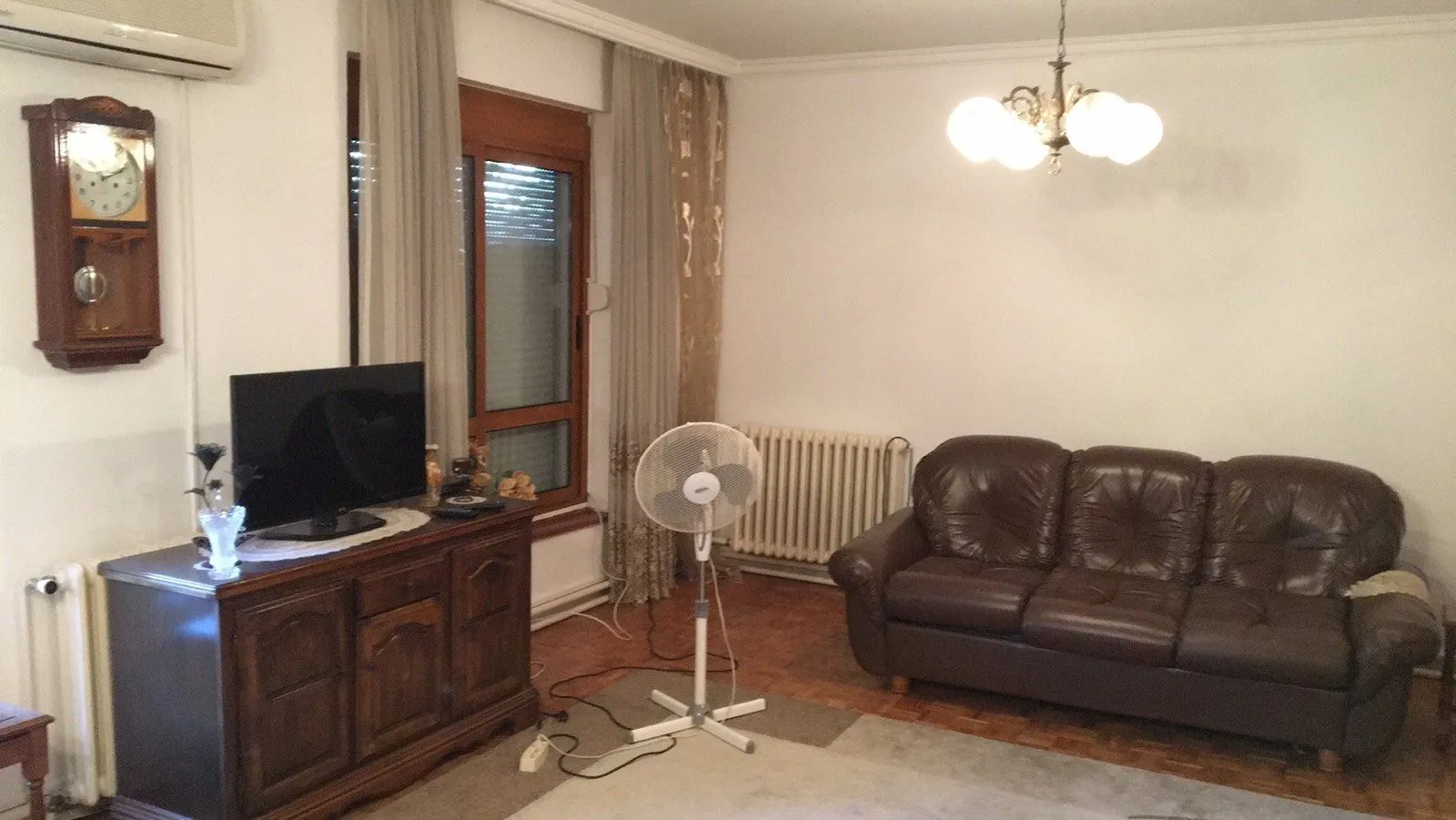 Living room with a leather sofa and a TV stand.