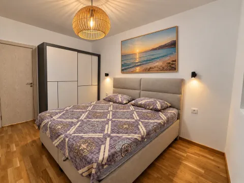 Furnished bedroom with a double bed, wardrobe, and a beach painting on the wall. - image 3