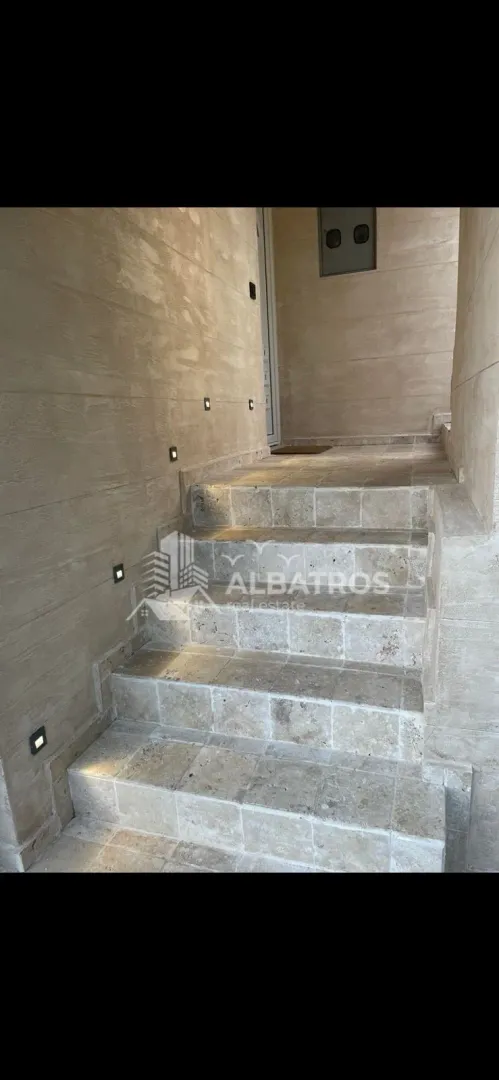 Stone-clad entrance stairs with built-in lighting.
