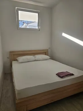 Spavaća soba sa bračnim krevetom i prozorom na zidu. - image 4