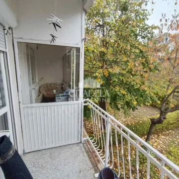 Natkriveni balkonski prostor sa pogledom na drveće i dvorište. - image 8