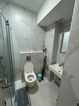 Modern bathroom with a shower cabin, toilet, and sink. - image 5