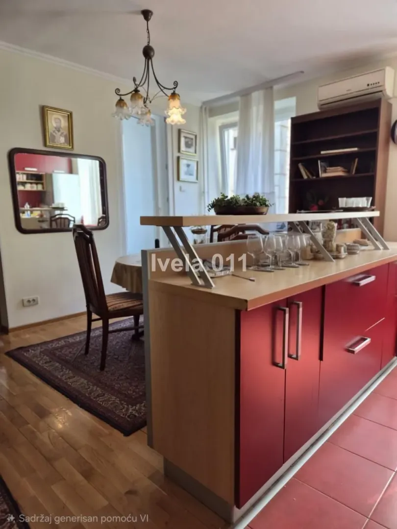Kitchen with red cabinets and a dining area in the background.