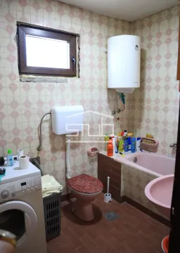 Older furnished bathroom with a bathtub, toilet, sink, and washing machine. - image 7