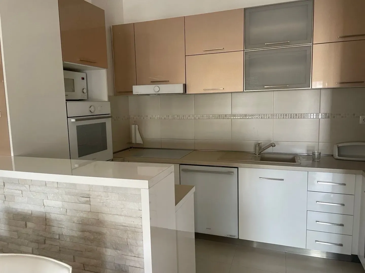 Modern kitchen with built-in appliances and a breakfast bar.