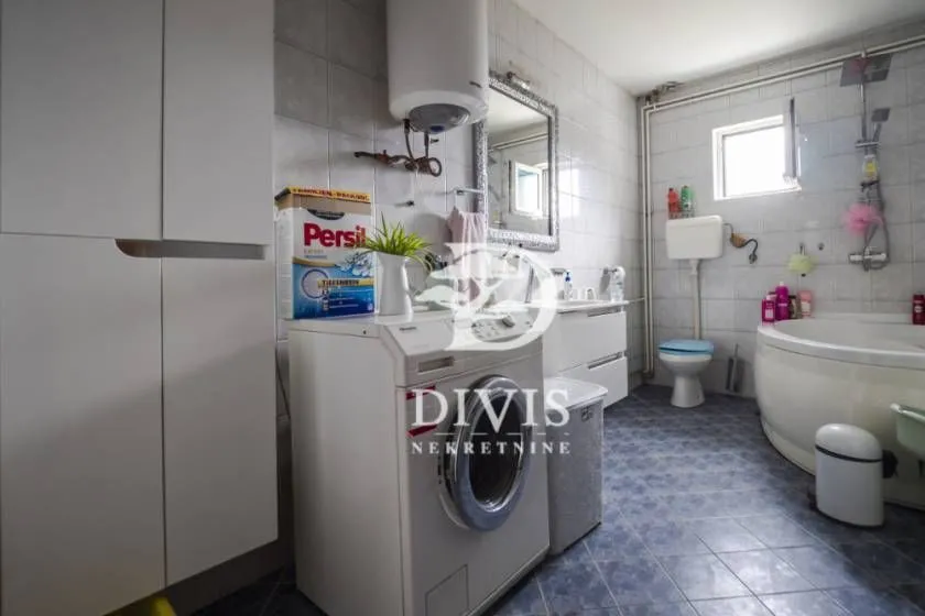 Kupatilo opremljeno kadom, umivaonikom, WC šoljom i mašinom za veš.