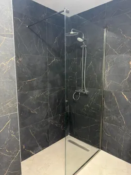 Moderna tuš kabina sa tamnim keramičkim pločicama sa teksturom mermera. - image 10