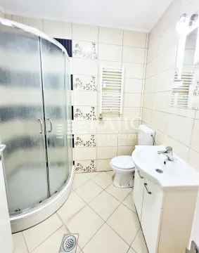 Tidy bathroom with a shower cabin, washbasin, and toilet. - image 10