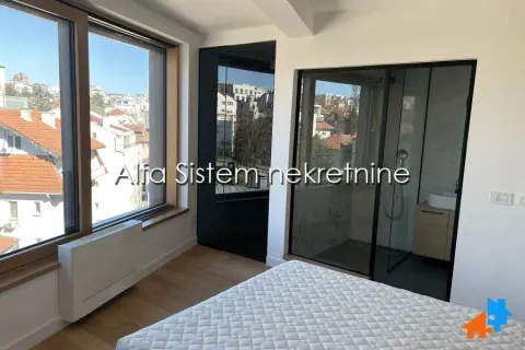 Bedroom with city view and a glass partition wall towards the bathroom. - image 8