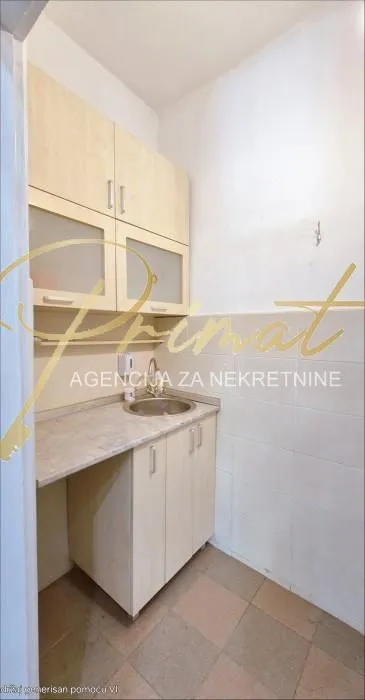 Small kitchen with light wood cabinets and a sink.