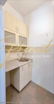 Small kitchen with light wood cabinets and a sink. - image 4