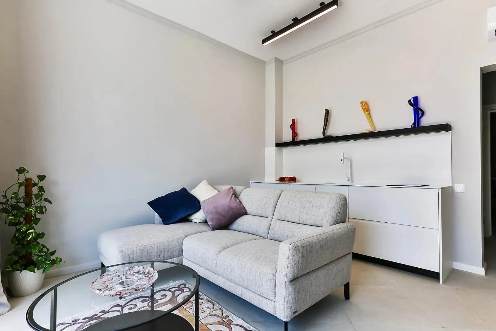 Living room with a grey sectional sofa, coffee table, and decorative elements.