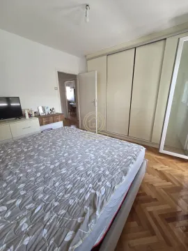 Nameštena spavaća soba sa bračnim krevetom, velikim ormanom i TV komodom. - image 9