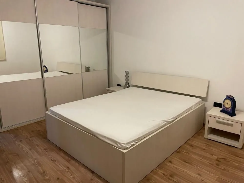 Bedroom with a double bed and a built-in wardrobe with mirrors.