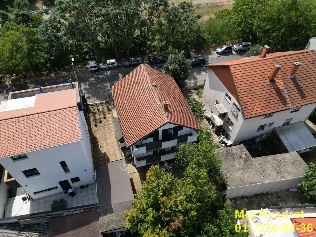 Pogled iz vazduha na kuće i okolno dvorište sa zelenilom.