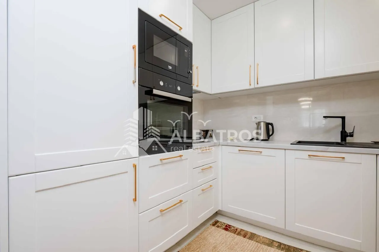 White kitchen with built-in appliances and white countertop.