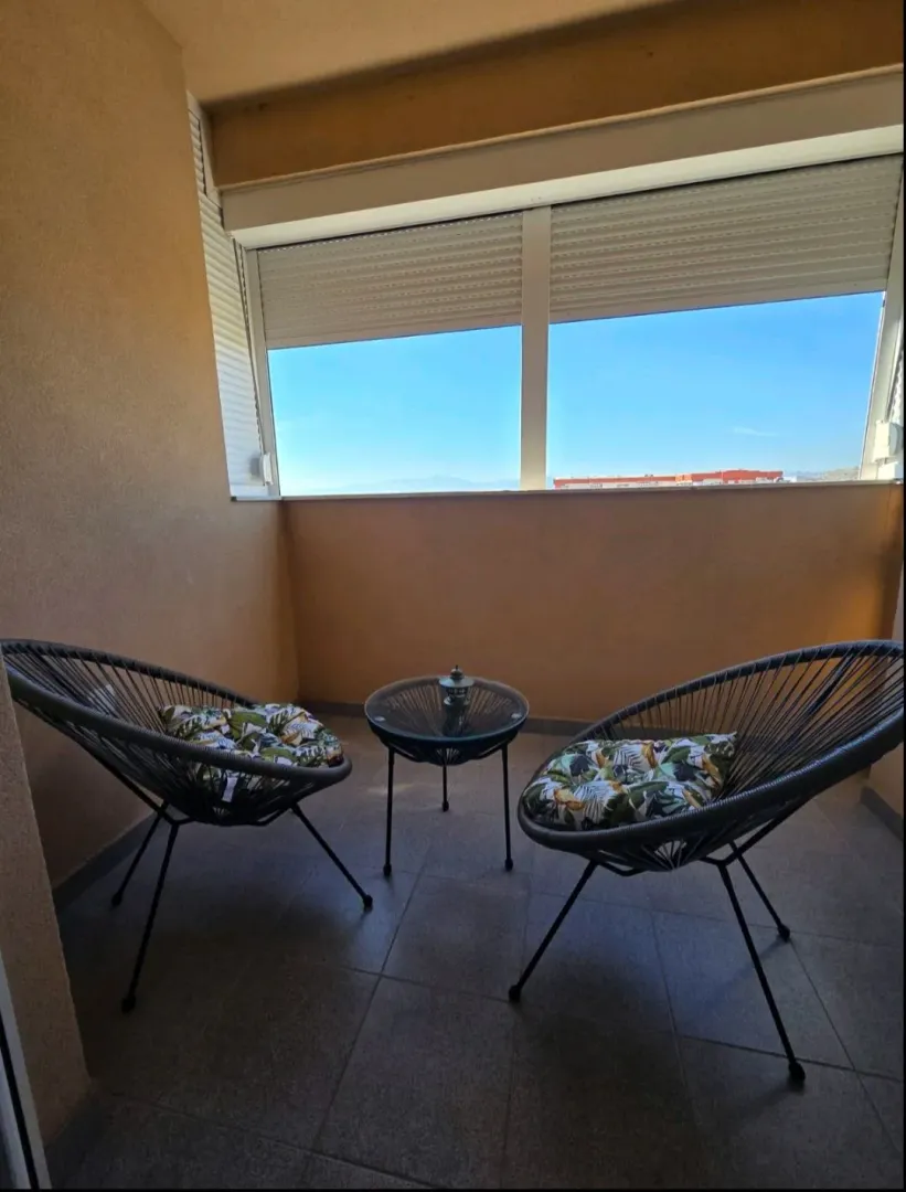 Manji namješteni balkon sa dvije fotelje i stočićem.