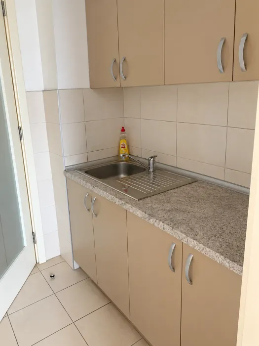 Small kitchen with a sink, countertop, and wall cabinets.