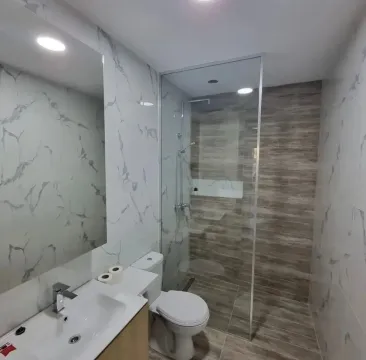 Modern bathroom equipped with a walk-in shower and sink. - image 6