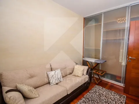 Living room with a beige sofa and a built-in wardrobe with sliding glass doors. - image 5