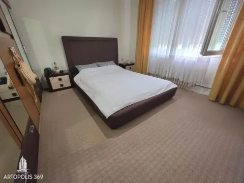 Nameštena spavaća soba sa bračnim krevetom, noćnim stočićima i prozorom sa zavesama. - image 7