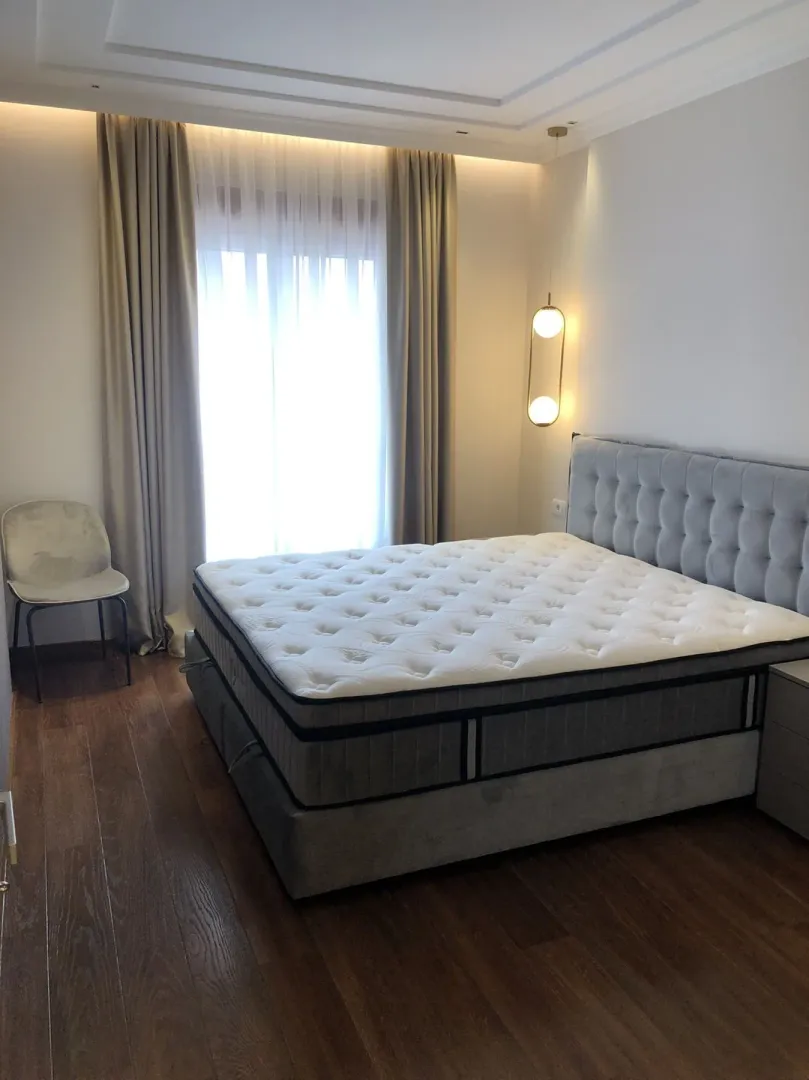 Bright bedroom with a large double bed and modern lighting.