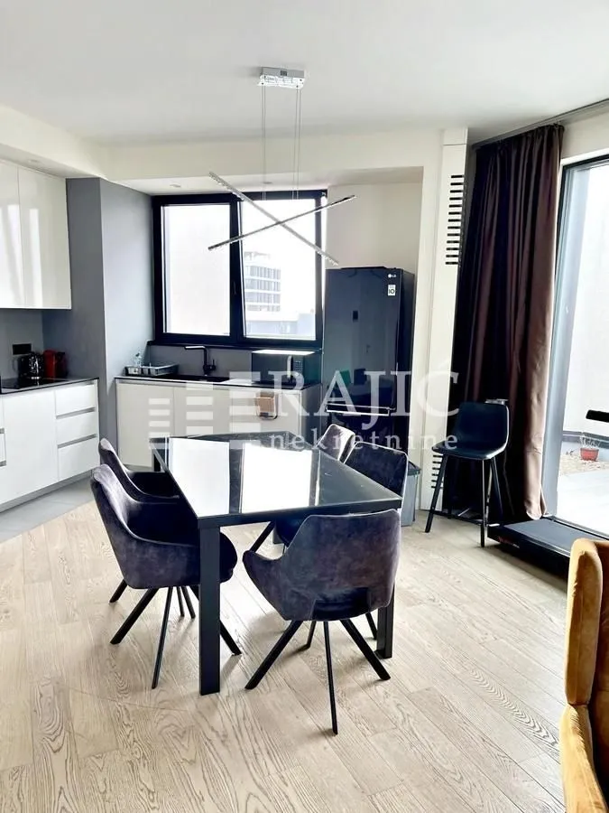 Modern kitchen with dining area and access to the terrace.