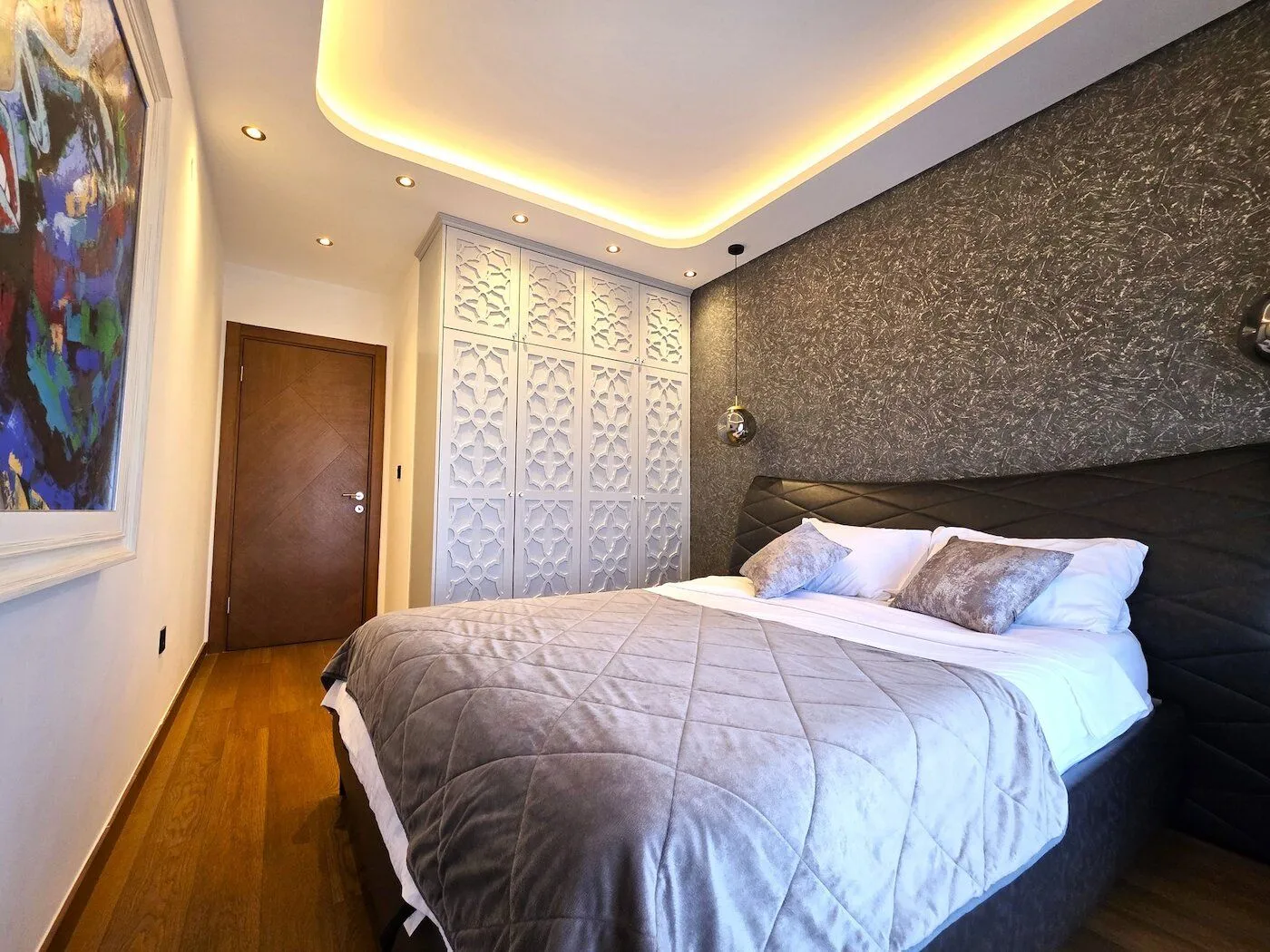 Modern bedroom with a double bed and built-in wardrobes.