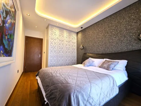 Modern bedroom with a double bed and built-in wardrobes. - image 9