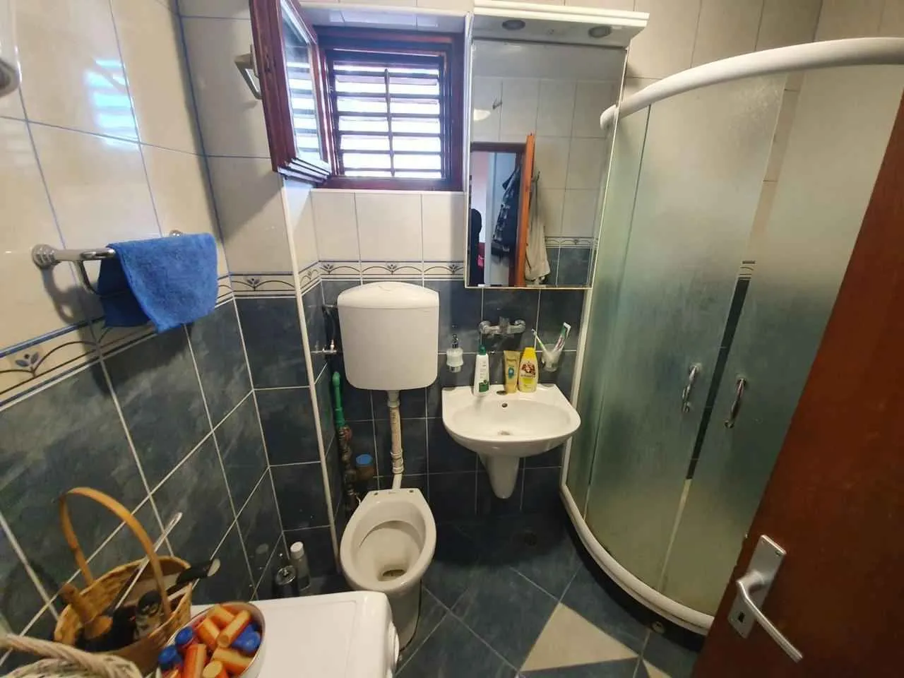 Manje kupatilo sa tuš kabinom, umivaonikom i WC šoljom.