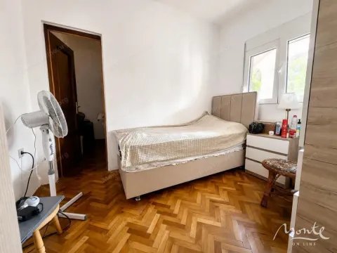 Namještena spavaća soba sa krevetom, noćnim stočićem i parketom na podu. - image 13