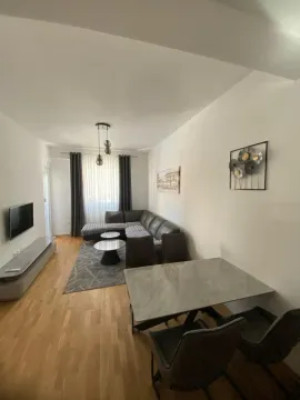 Living room with a corner sofa, TV and dining table. - image 2