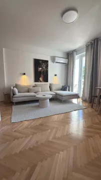 Dnevna soba sa ugaonom garniturom, stočićem i parketom na podu. - image 3