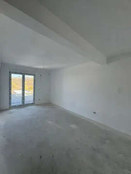 Prazna neopremljena prostorija sa belim zidovima i balkonskim vratima. - image 2