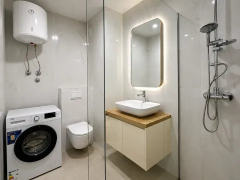 Savremeno opremljeno kupatilo sa tuš kabinom, umivaonikom i veš mašinom. - image 9
