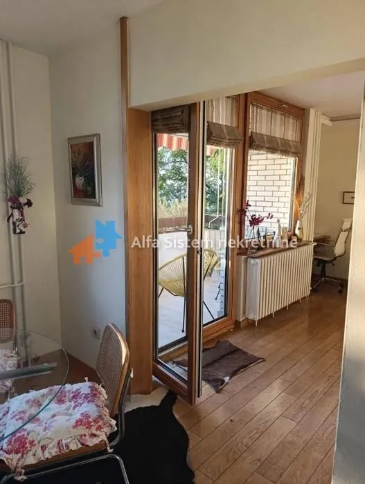 Pogled iz dnevne sobe na terasu i trpezarijski deo sa drvenim podom.