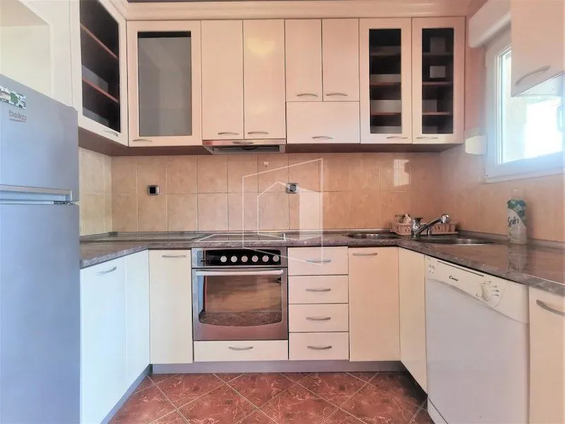 Small kitchen with fitted cabinets and white goods.